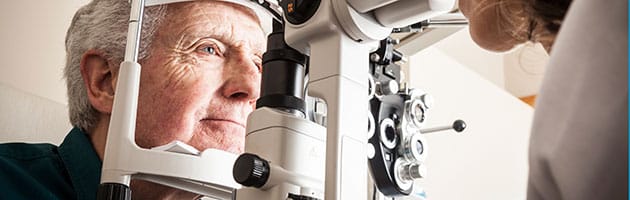 older man staring into vision testing machine to test vision